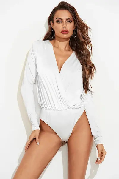 Woman wearing a white long-sleeve swimsuit against a plain background.