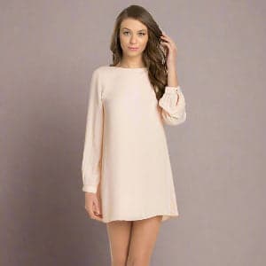 Woman wearing a beige dress against a plain background.
