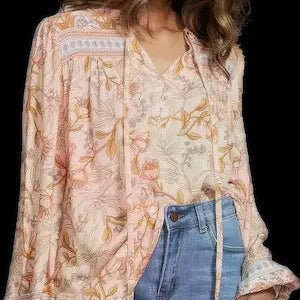 Woman wearing a floral blouse and denim shorts on a black background.