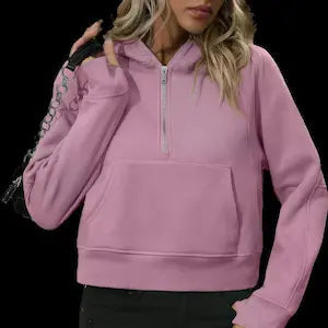 Pink hoodie worn by a person on a black background.
