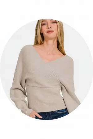 Woman wearing a beige sweater with a white background.