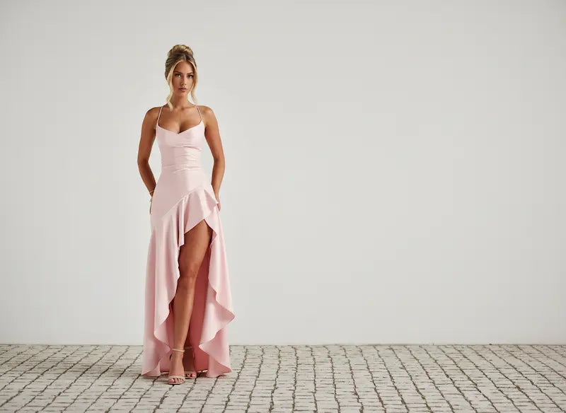 Model wearing a pink party dress for event season.
