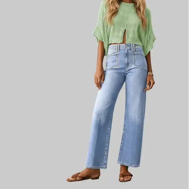 Person wearing light blue jeans and a green top on a gray background.