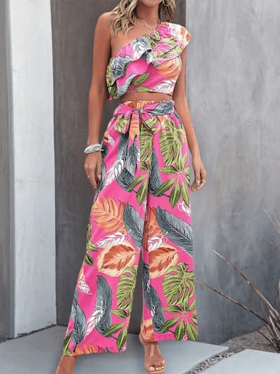 Woman wearing a colorful, floral two-piece outfit against a gray background.