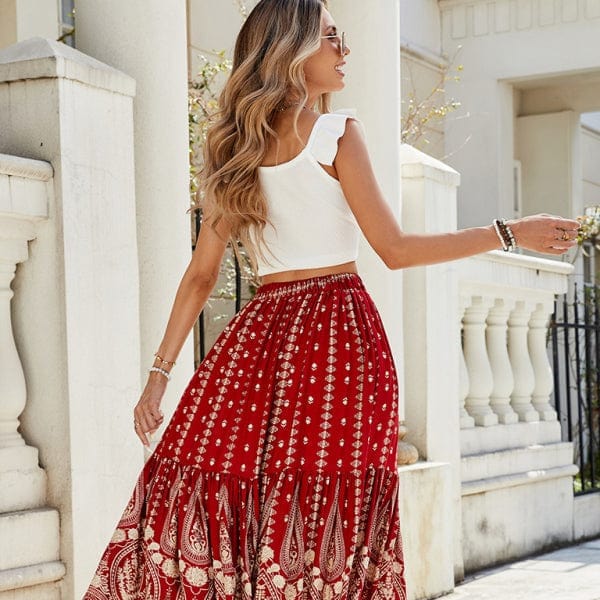 model showcasing a boho-chic outfit with vibrant red maxi skirt and white crop top.