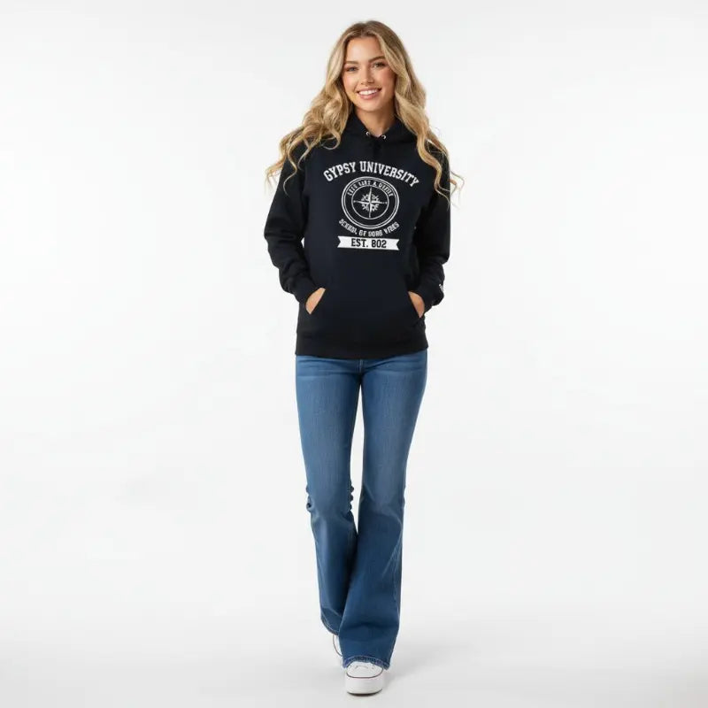 Gypsy University black hoodie with embroidered compass rose crest and "Live Like a Gypsy" text, worn by blonde woman with high-waisted jeans.